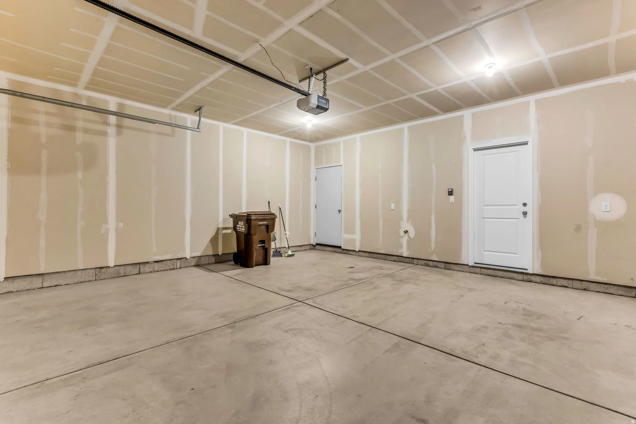 Concrete flooring, overhead lighting, and two interior doors