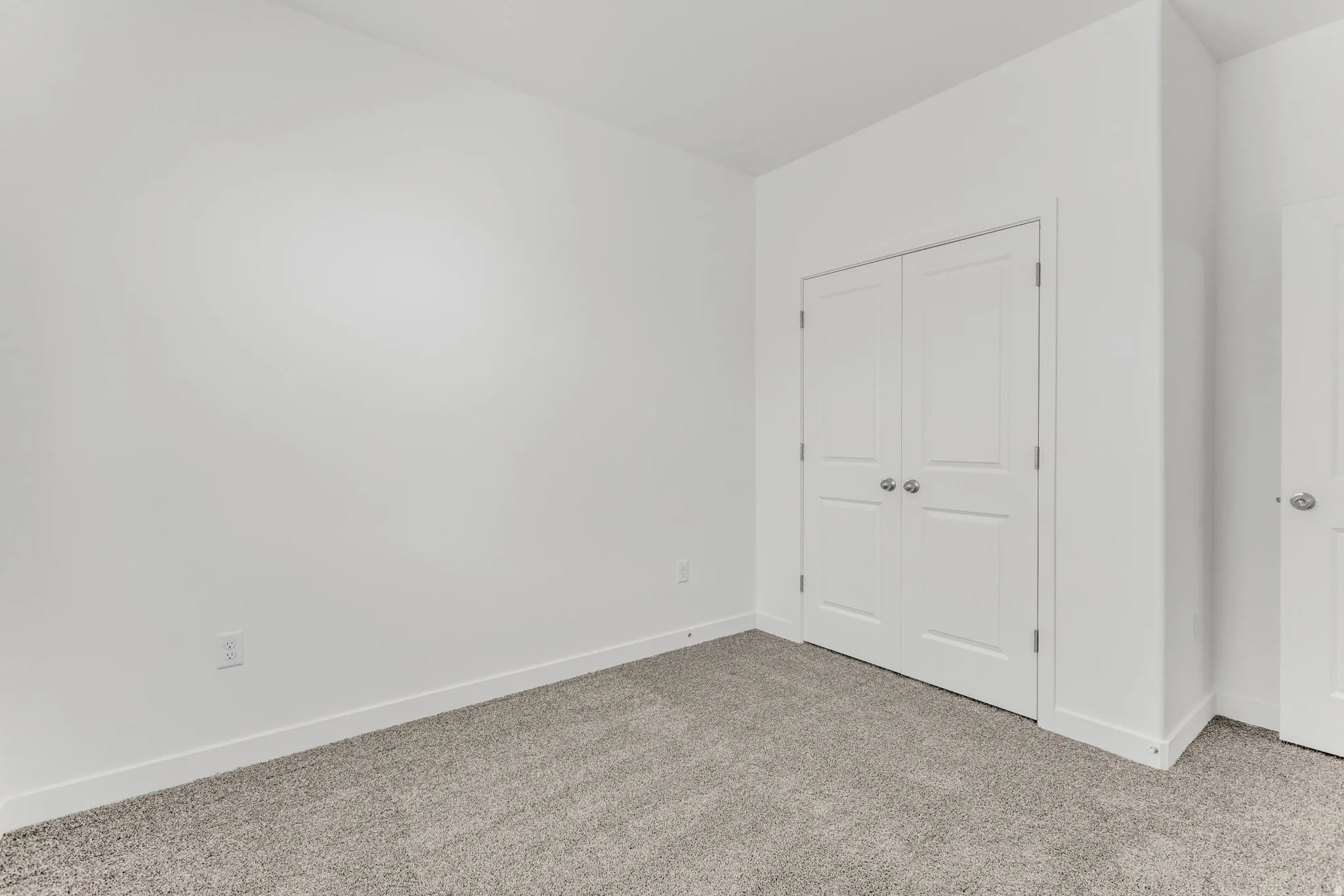 Neutral-toned carpeting, white walls, and white trim