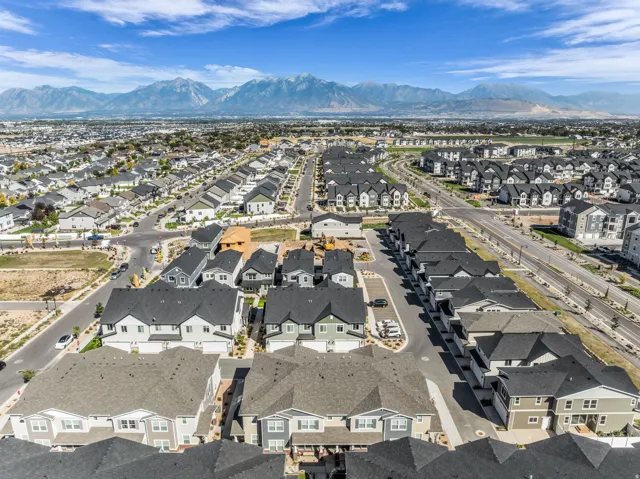 Residential neighborhood featuring a variety of housing styles, paved roadways, and mountain backdrop