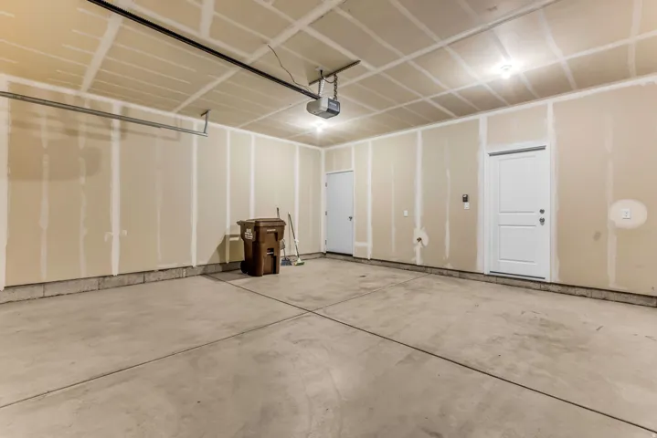 Concrete flooring, overhead lighting, and two interior doors