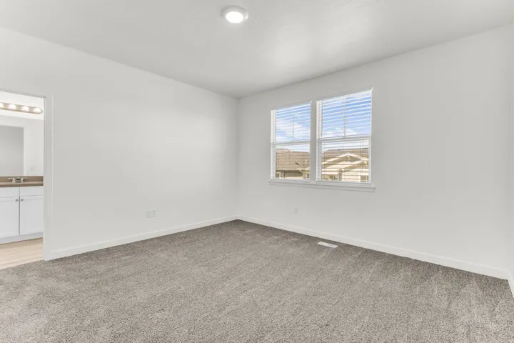 Neutral wall paint, plush carpet flooring, recessed ceiling lighting, and window blinds