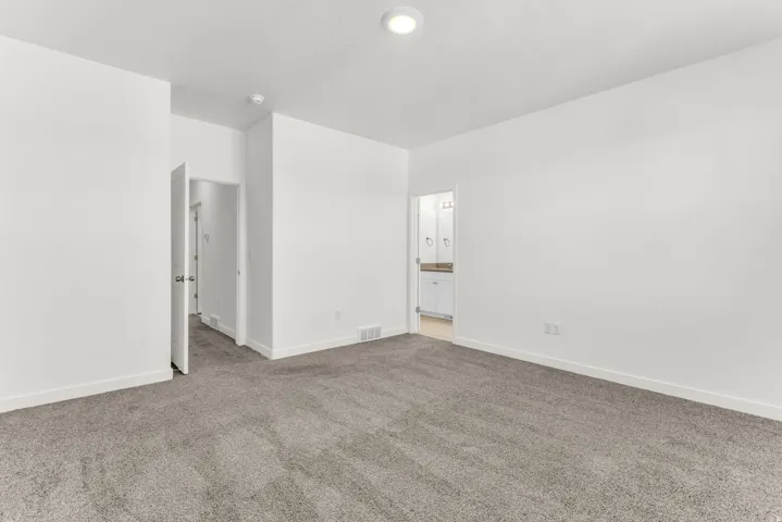 Plush gray carpeting, white painted walls, and ceiling-mounted lighting