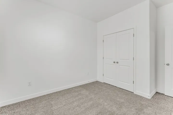 Neutral-toned carpeting, white walls, and white trim