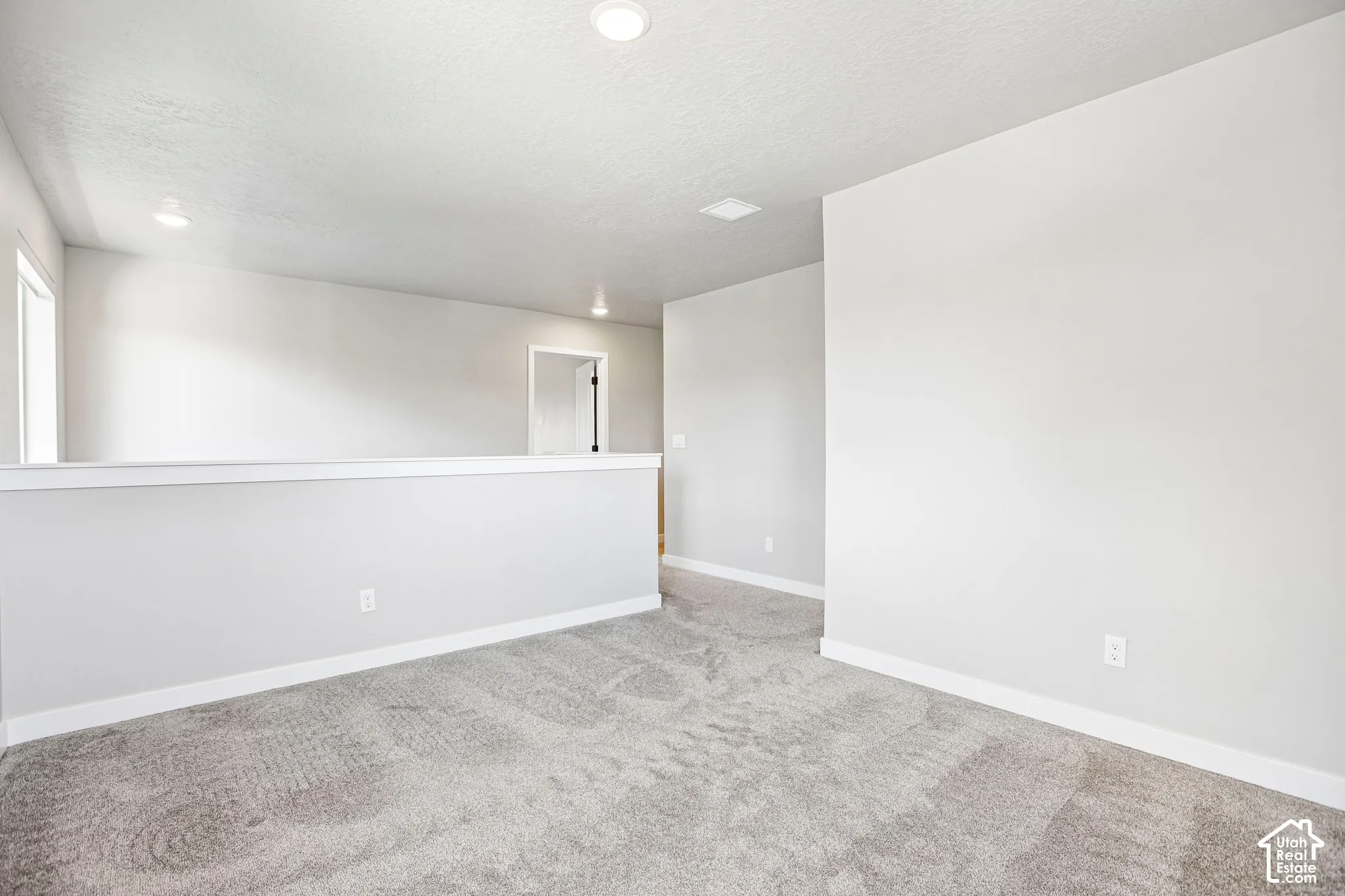 Open loft area featuring recessed lighting, a neutral color palette, and gray carpet