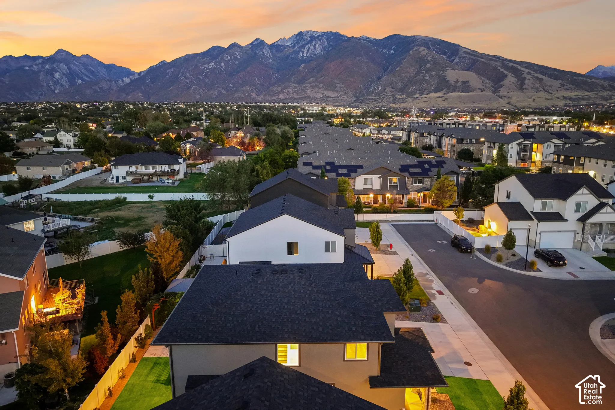 Neighborhood setting with a street, residential structures, and mountain backdrop