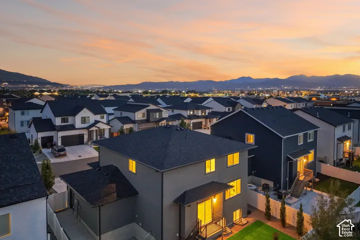 Modern residential community with distinct architectural styles, featuring dark roofing and mountain backdrops
