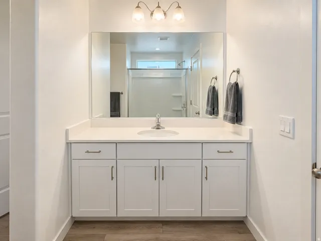 White vanity with an integrated sink and light-colored countertop