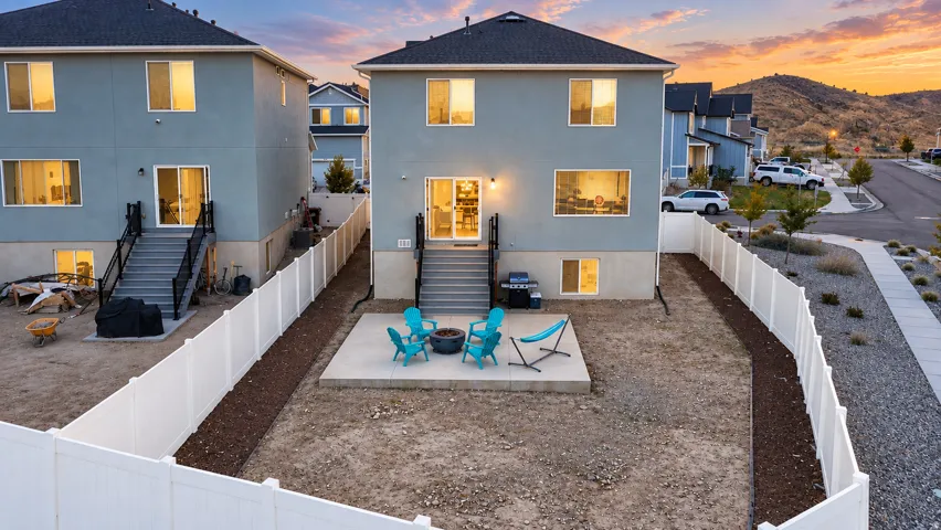 Private fenced backyard featuring a concrete patio and a raised deck with stairs