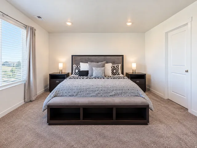Plush carpeting throughout, complemented by a large window with blinds and drapes, and recessed ceiling lighting