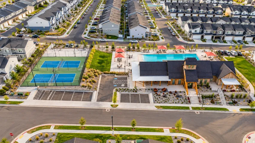 Community amenities featuring multiple tennis courts, a swimming pool, and a clubhouse with covered outdoor spaces