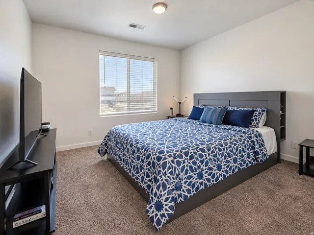 Neutral color palette, window with horizontal blinds, flush mount ceiling light, and wall-to-wall carpeting