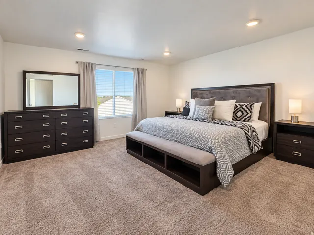 Plush carpeted flooring, recessed ceiling lighting, a large window with blinds, and a built-in dresser