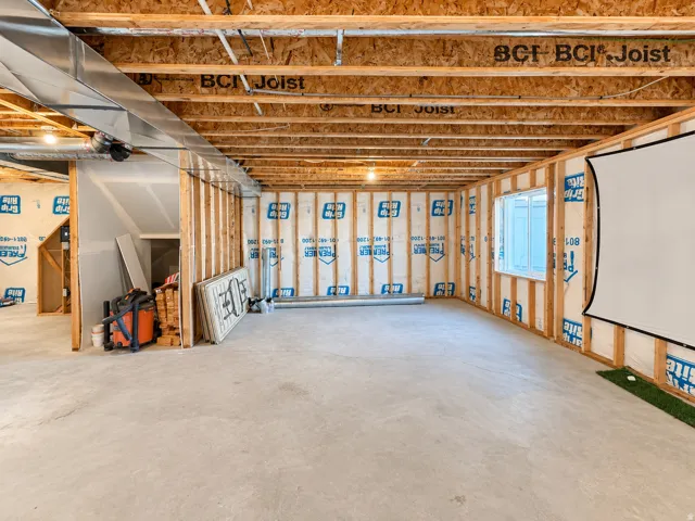Unfinished basement featuring exposed BCI Joist ceiling, framed walls, and concrete flooring