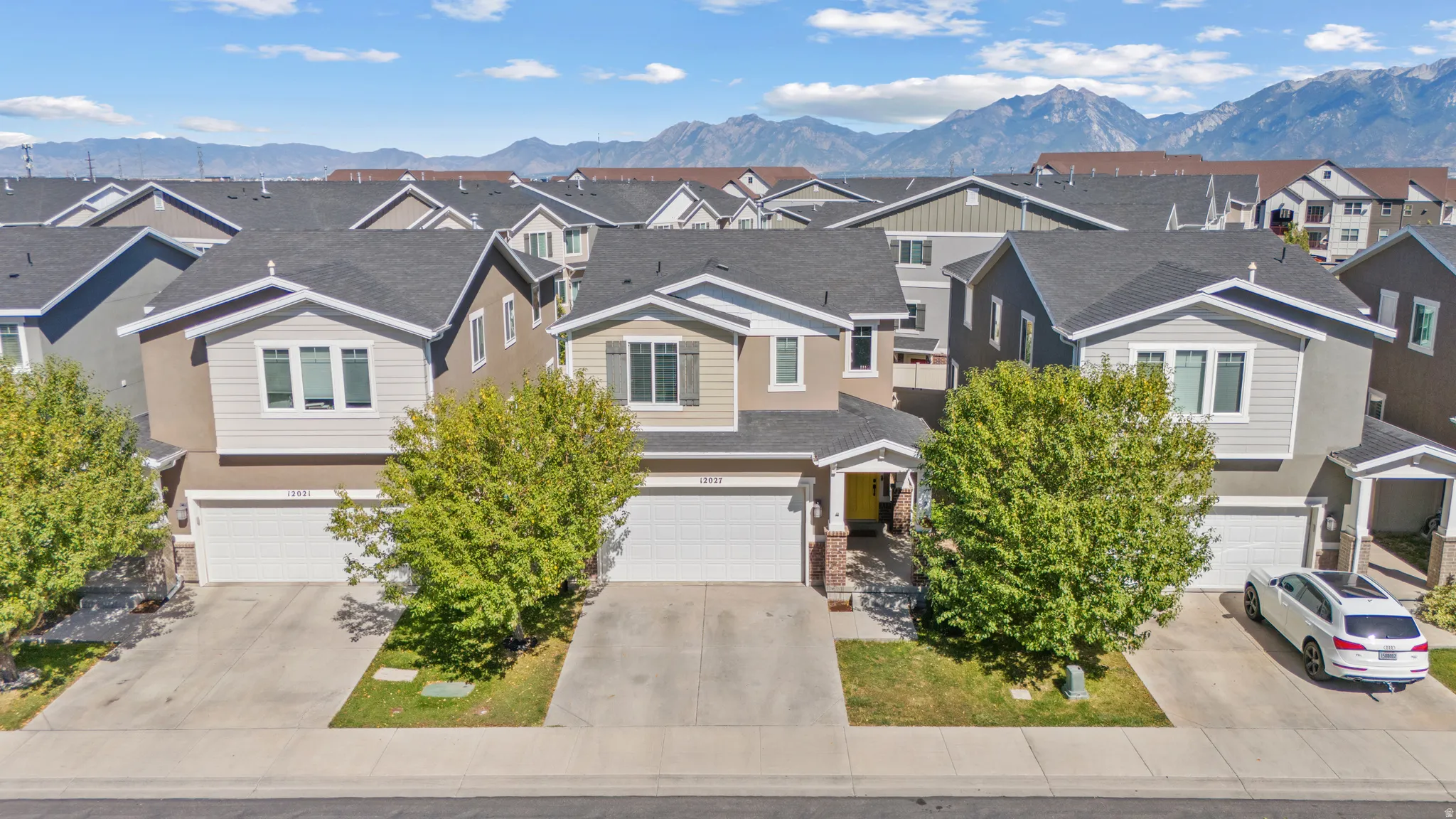 Contemporary exterior with a two-car garage, covered entry, and mature landscaping