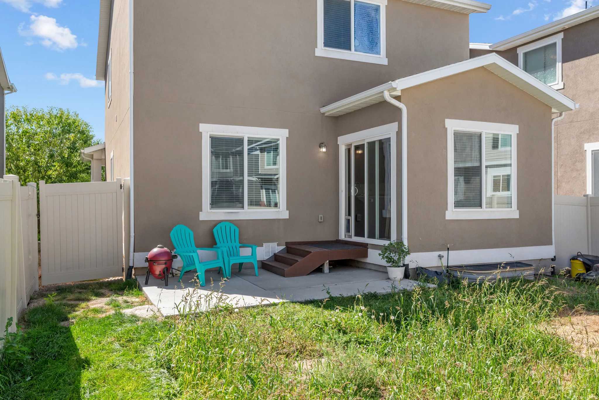 Private fenced yard with patio space, sliding glass door access, and a second-story window