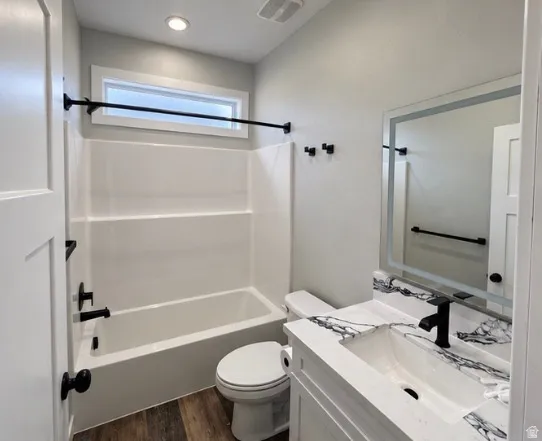 Bathroom featuring a vanity with a white finish, a patterned countertop, a built-in rectangular sink, and a black faucet