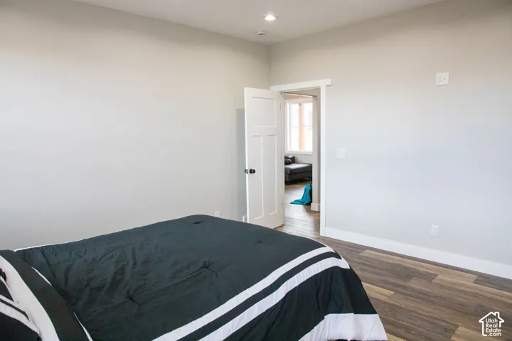 Wood-finish flooring with white trim and a recessed lighting fixture