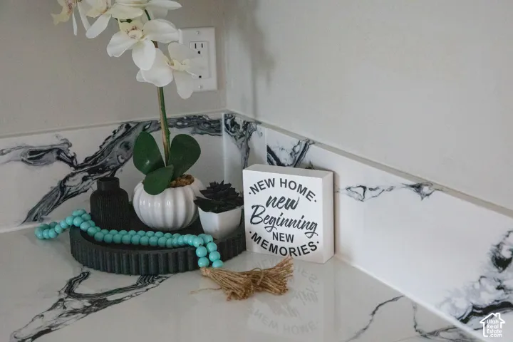 White countertop with black veining, complementary backsplash, and a white wall finish