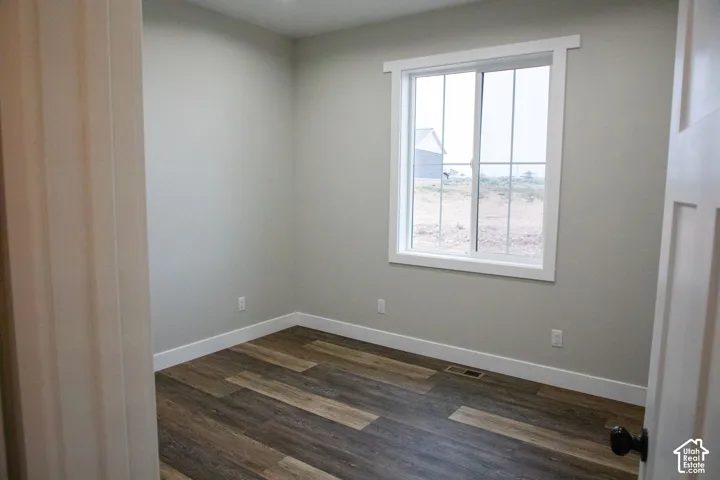 Wood-finish flooring, white trim, light-toned walls, and a white-framed window