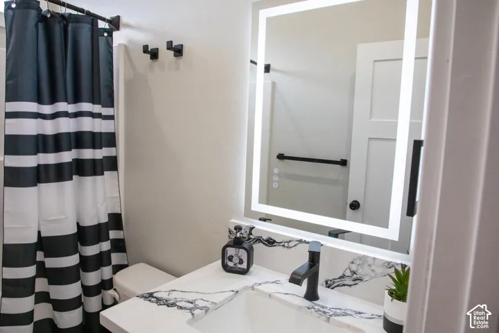 Vanity with integrated rectangular sink, matte black faucet, and patterned countertop