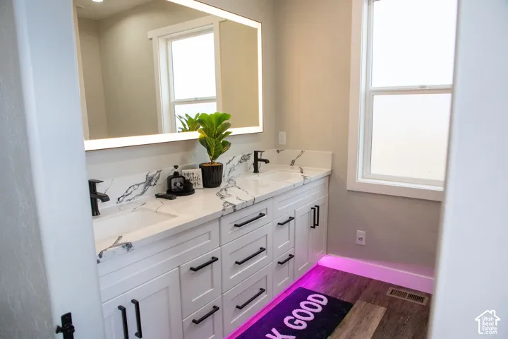 Dual vanity with integrated sinks, modern matte black faucets, and stone-finish countertops with matching backsplash