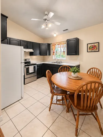 Kitchen featuring dark cabinetry, white countertops, tile flooring, and stainless steel appliances