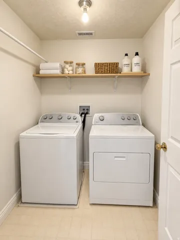 Dedicated laundry area with a clothes rod, light wood-finish shelving, and light-toned flooring