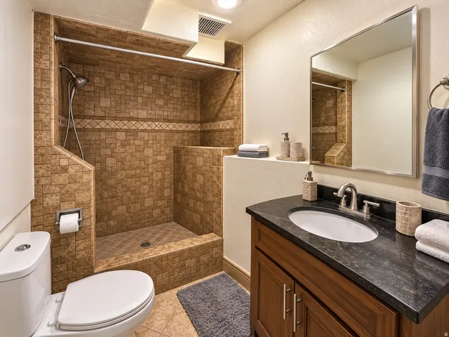 Tiled shower with decorative accent band and built-in shelf