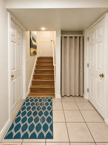 Staircase with wood-finish treads, white risers, and a single handrail