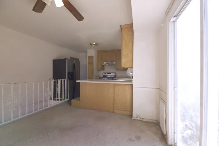 Kitchen featuring wood-finish cabinetry, built-in range, and stainless steel refrigerator
