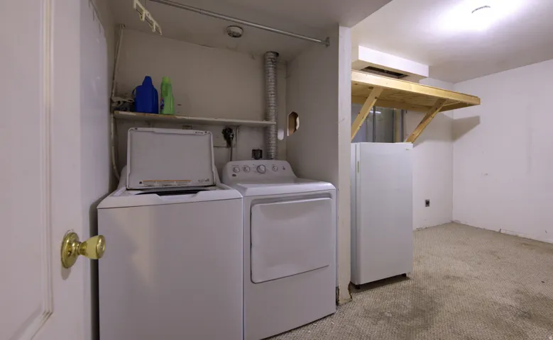 Laundry area featuring a top-load washer, front-load dryer, and overhead shelving