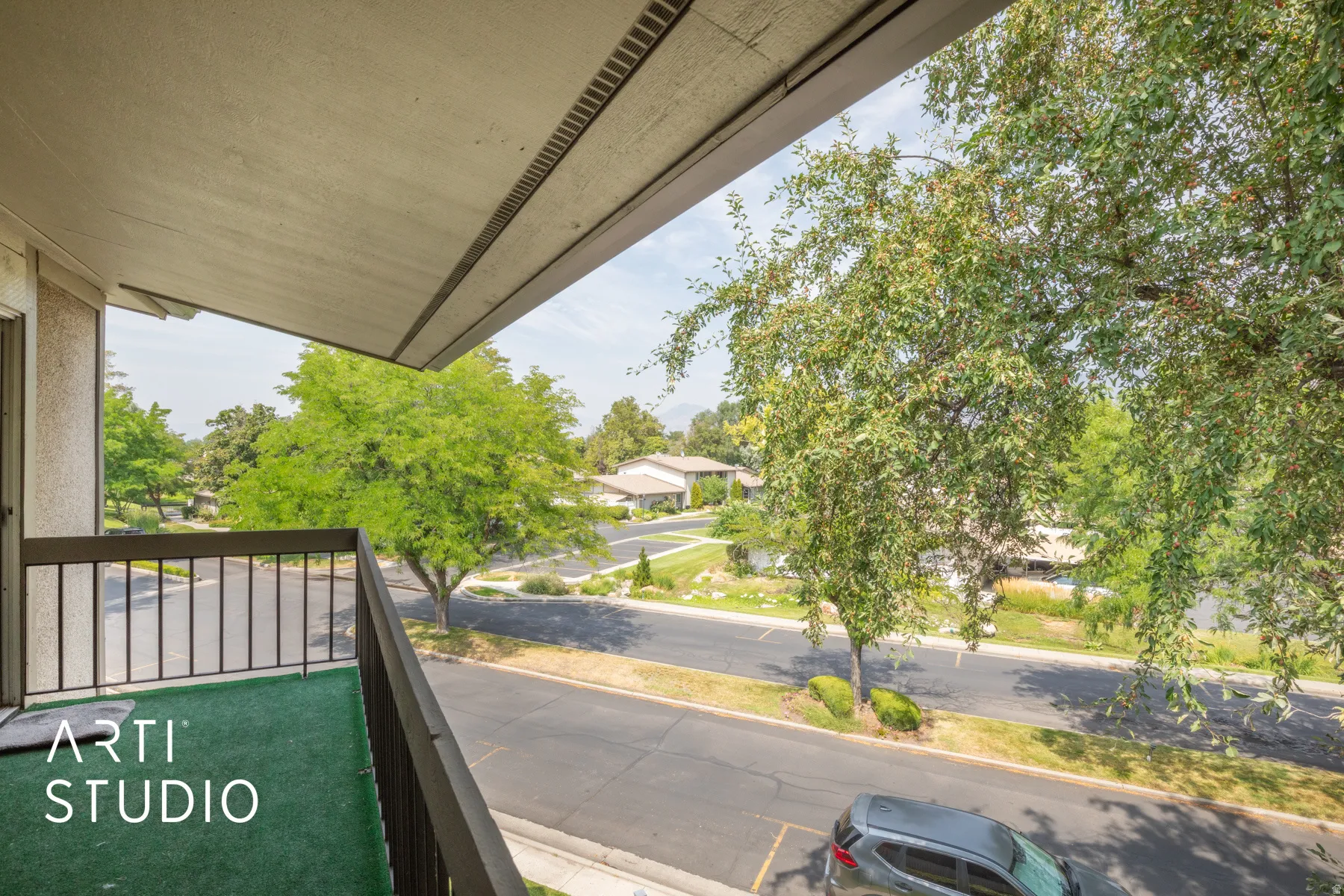 Balcony with metal railing and green artificial turf flooring