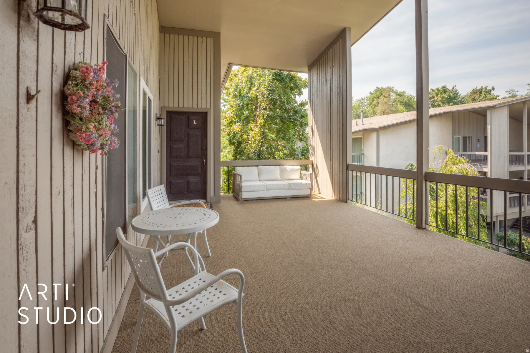 Expansive private balcony with durable flooring, vertical wood-finish siding, and dark railing accents