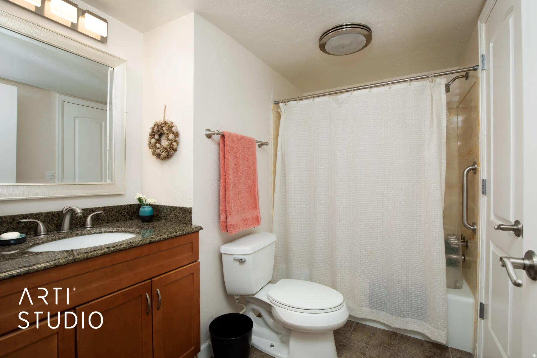 Wood-finish vanity with an undermount sink, stone countertop, and brushed nickel fixtures