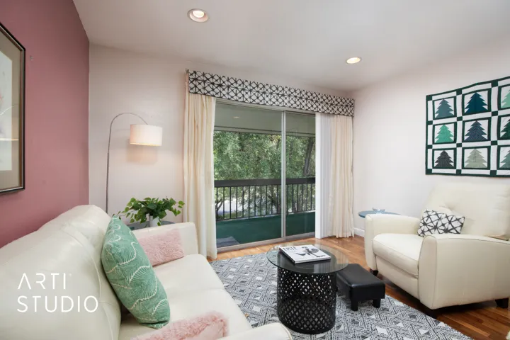 Sliding glass door opening to an outdoor balcony, recessed lighting, wood-finish flooring, and a decorative valance