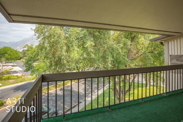 Balcony featuring a mountain backdrop and mature trees