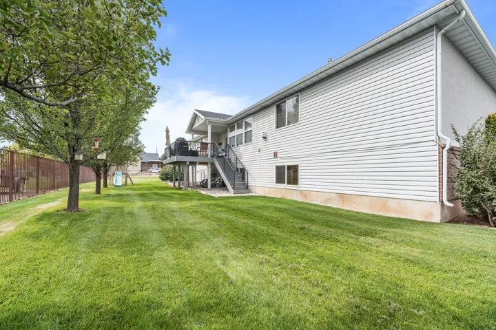 Expansive green lawn with mature trees and a fenced perimeter