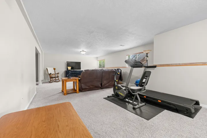 Spacious room featuring carpeting, light-colored walls, and a window providing natural light