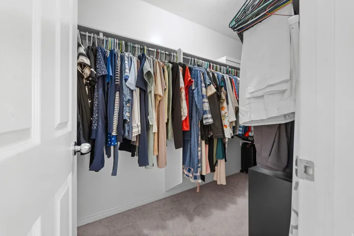 Primary Bedroom built-in closet system with multiple hanging rods and shelving
