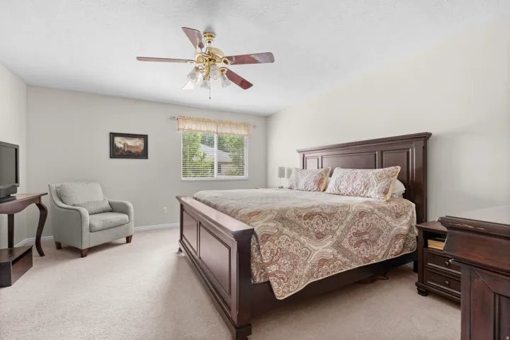 Primary Bedroom, carpeted flooring, a window with blinds, a ceiling fan with integrated lighting, and light-colored walls