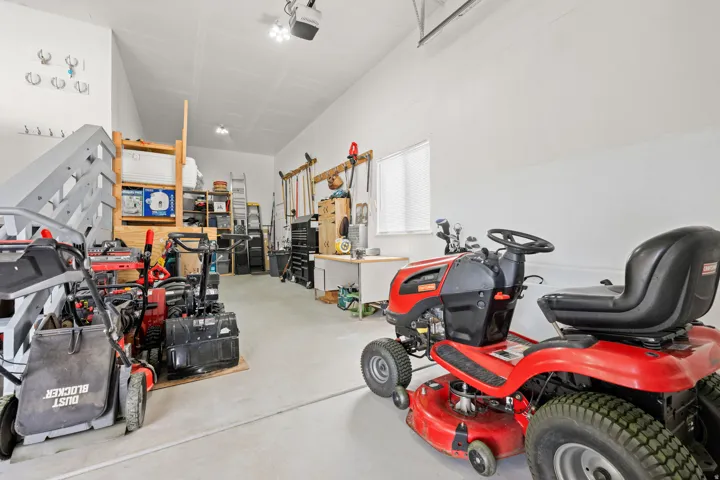 Attached  extra deep 3rd garage with a high ceiling, concrete flooring, and an elevated storage area