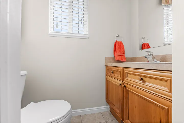 Bathroom featuring a vanity with wood cabinetry, a built-in sink, and a mounted mirror