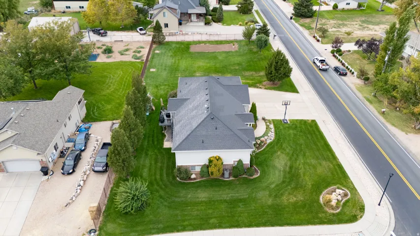 Impressive aerial view showcasing this residence's manicured lawn, mature landscaping with established trees, and circular garden feature