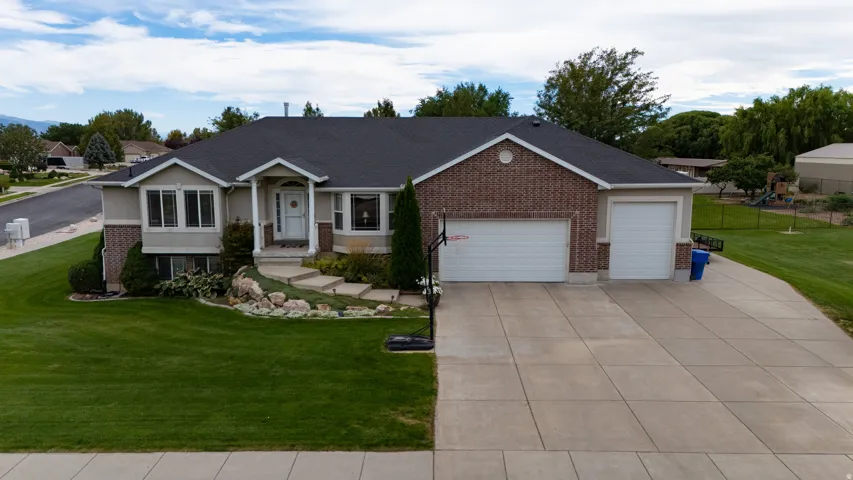 Stucco and brick exterior with a dark shingle roof