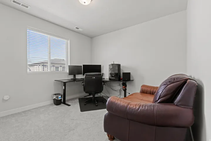 3rd bedroom with white painted walls, light carpet, and a single window featuring blinds and dark curtains
