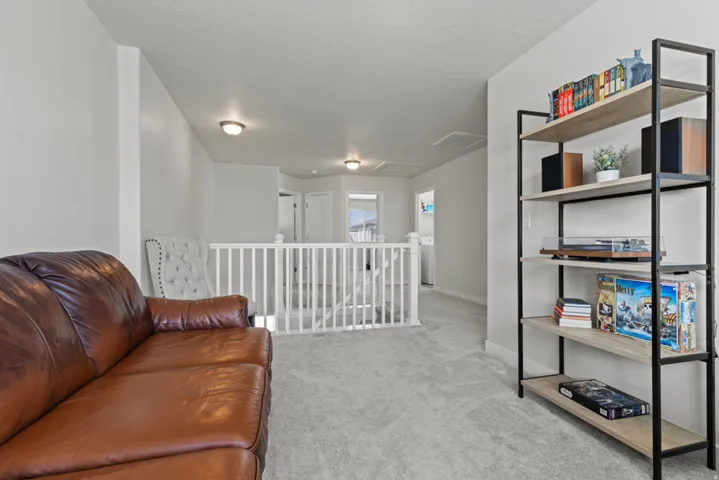 Carpeted flooring, white balustrade, and recessed lighting