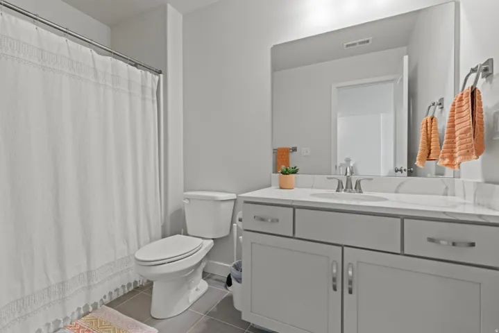 Main bathroom - vanity with a polished countertop, undermount sink, and chrome fixtures