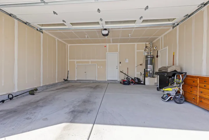 Spacious garage with concrete flooring, automatic overhead door, and interior access door