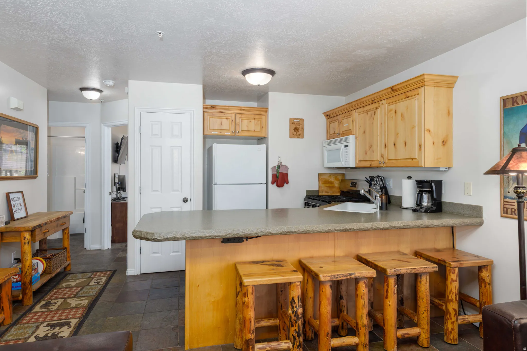 Kitchen featuring wood cabinetry, stone-look countertops, and a white sink