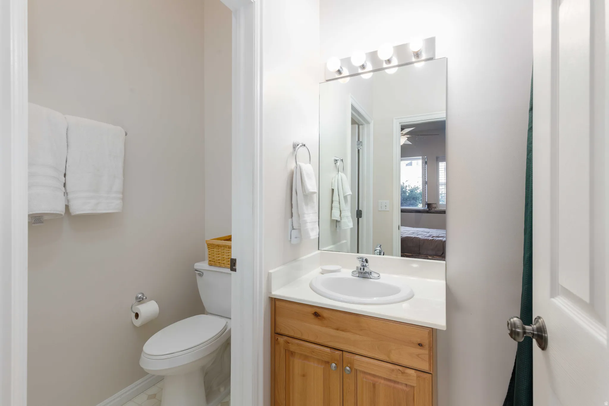 Vanity with a built-in sink, wood-finish cabinetry, countertop, and an overhead light fixture